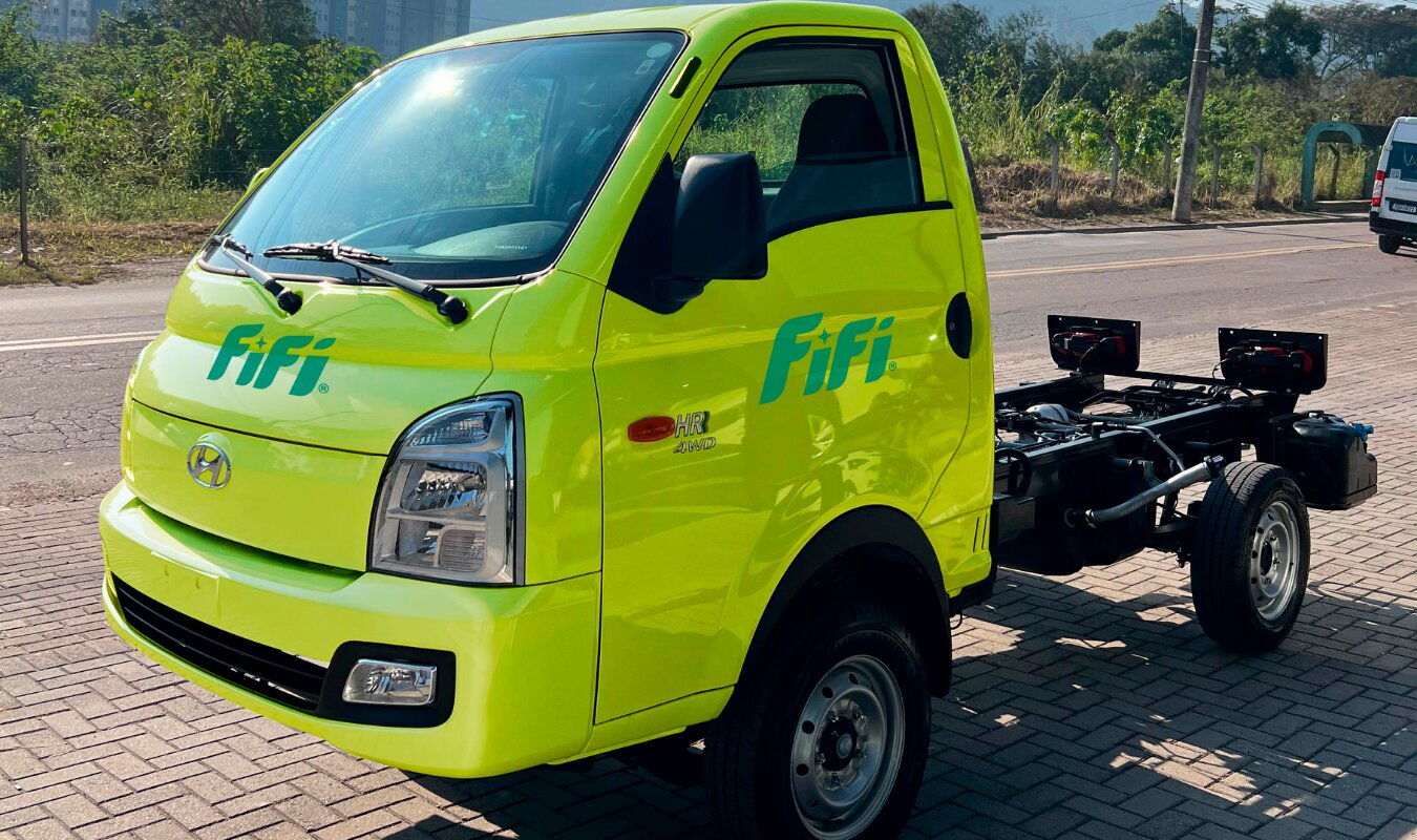 Caminhão leve verde-lima FIFI visto de frente em diagonal, na rua