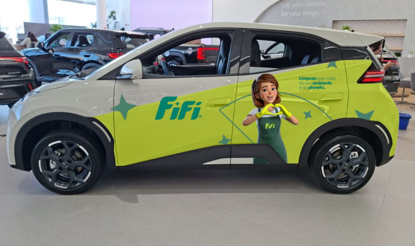 Carro compacto adesivado FIFI, com a personagem FIFI na porta traseira e a frase Limpeza que cuida do seu ambiente e do planeta, em showroom